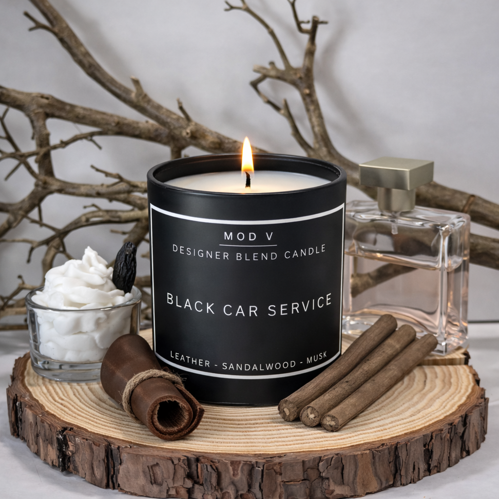 Candle labeled 'Black Car Service' with decorative items on a wooden platform.