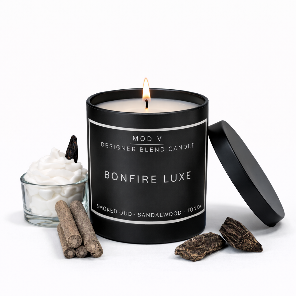 Black candle labeled 'Bonfire Luxe' with ingredients on a white background