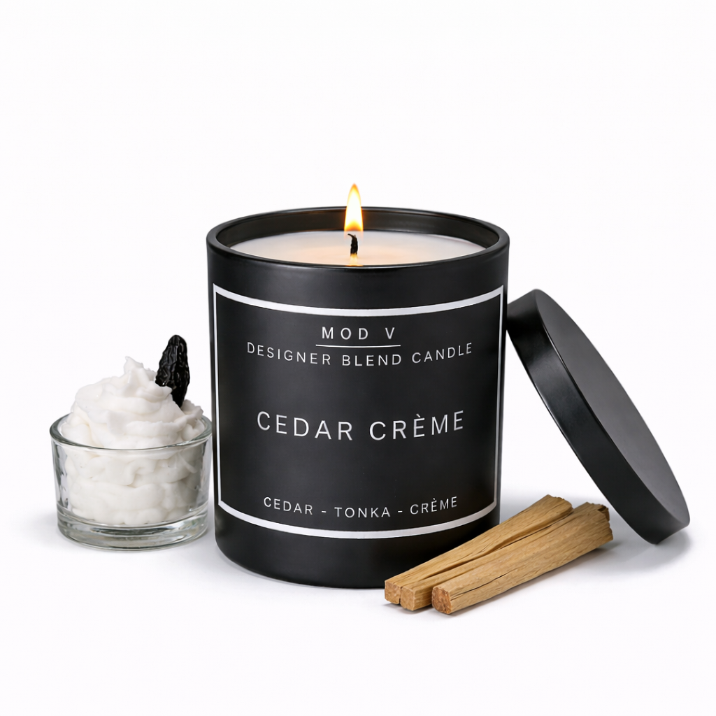 Candle labeled 'Cedar Crème' with a small glass of cream and cinnamon sticks on a white background