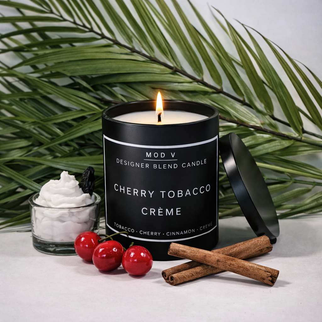 Candle labeled 'Cherry Tobacco Crème' with cherry, cinnamon stick, and green leaves in the background