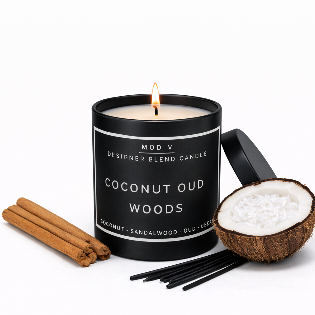 Candle labeled 'Coconut Oud Woods' with cinnamon sticks, a bowl of coconuts, and black wicks on a white background.