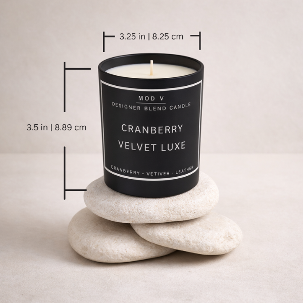Candle labeled 'Cranberry Velvet Luxe' on stones with measurements indicated