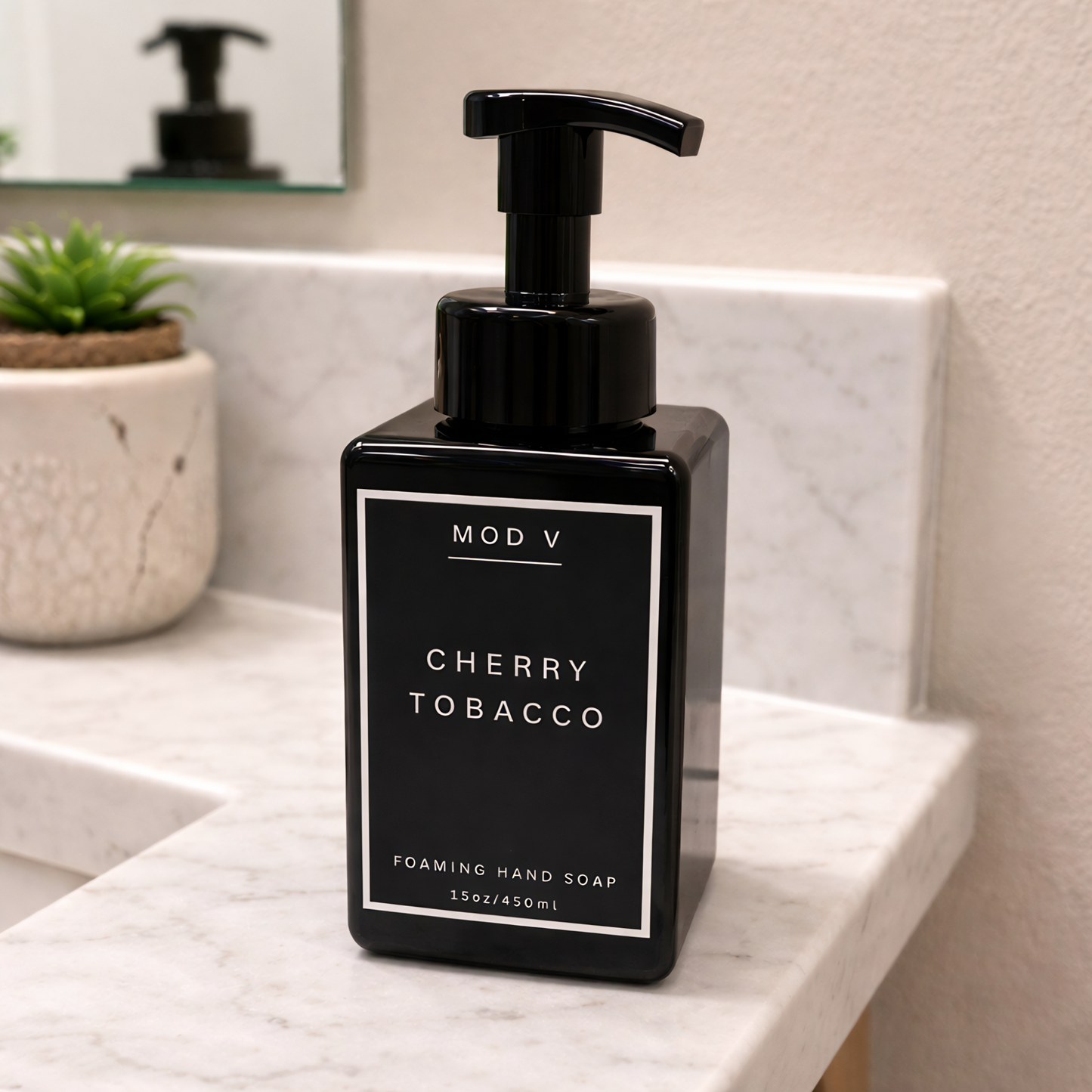 Black pump bottle of MOD V Cherry Tobacco foaming hand soap on a marble countertop.