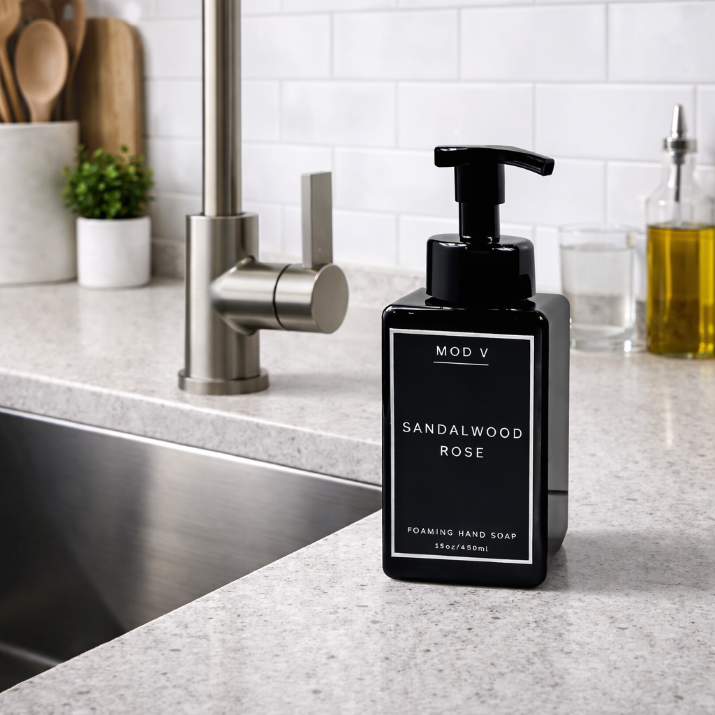 Black soap dispenser labeled 'Sandalwood Rose' on a kitchen counter.