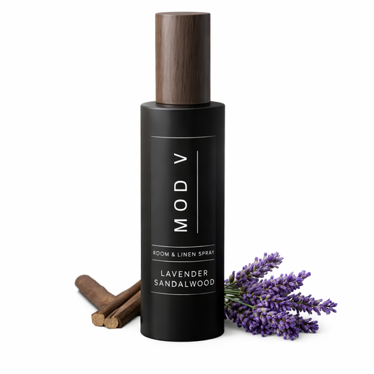 Black room & linen spray bottle with wooden cap, lavender, and cinnamon sticks on a white background