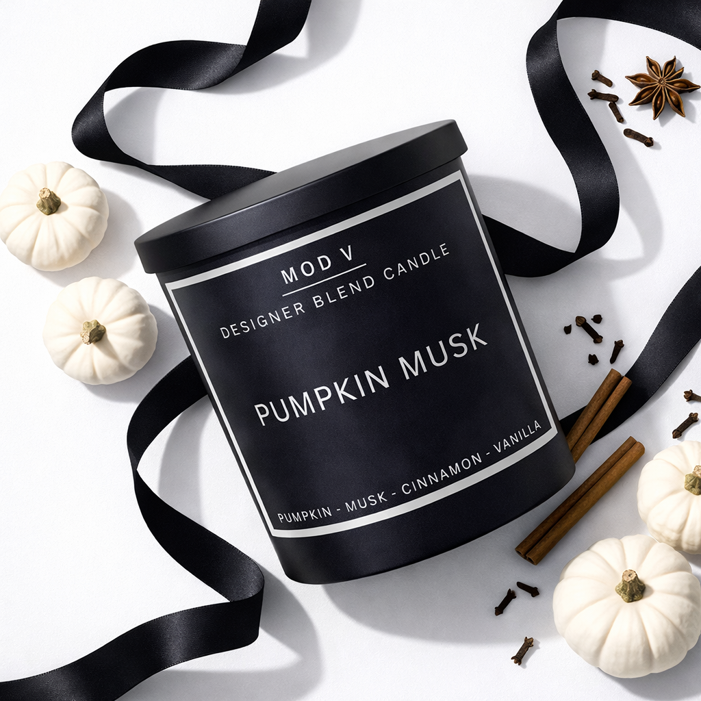 Black candle labeled 'Pumpkin Musk' with decorative elements on a white background