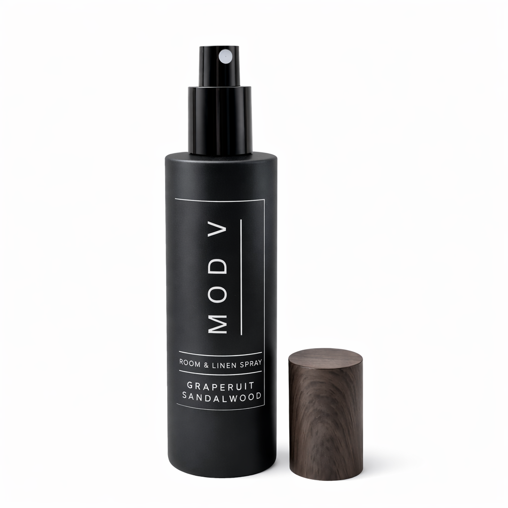 Black room & linen spray bottle with wooden diffuser on a white background
