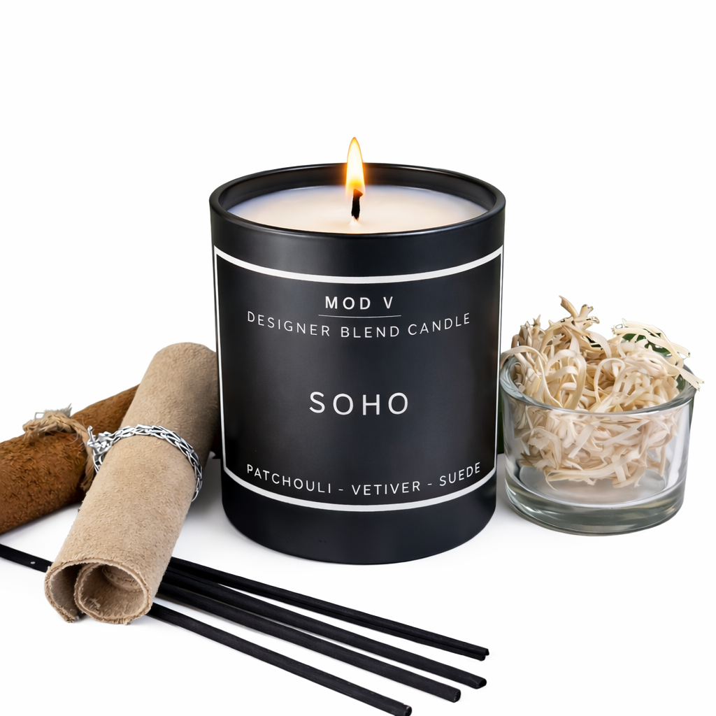 Black candle labeled 'Soho' with decorative items on a white background