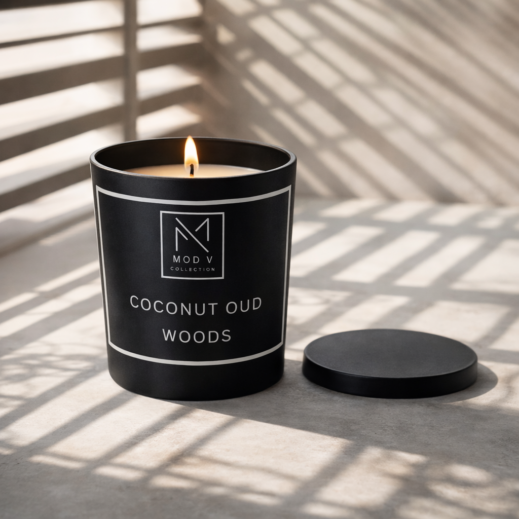 Black candle with 'Mod V Collection' label on a light surface with shadows